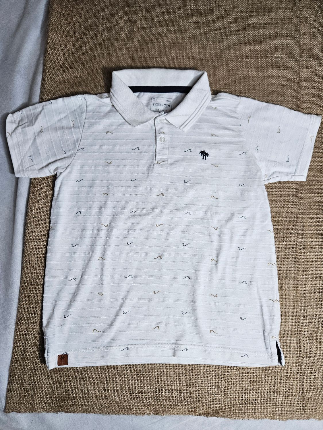 REMERA EN PIQUE PARA NIÑO, MANGA CORTA, BLANCA CON DISEÑO DE OLAS, Y BORDADO DE PALMERA. MARCA POIM. TALLE 5