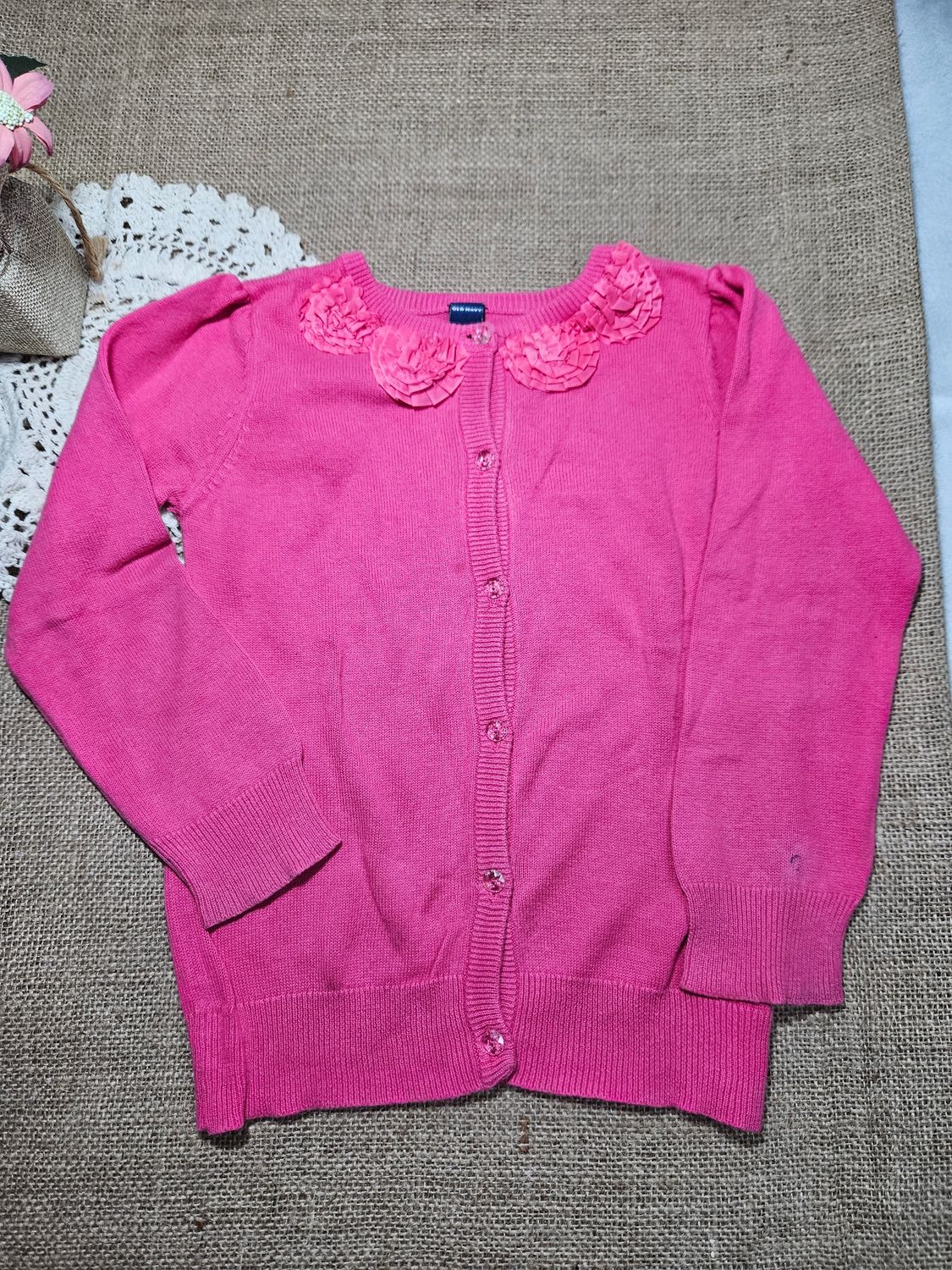 SACO PARA NIÑA, EN HILO FINO, MARCA OLD NAVY, TALLE 4. COLOR FUCCIA CON DETALLES DE FLORES EN CUELLO.