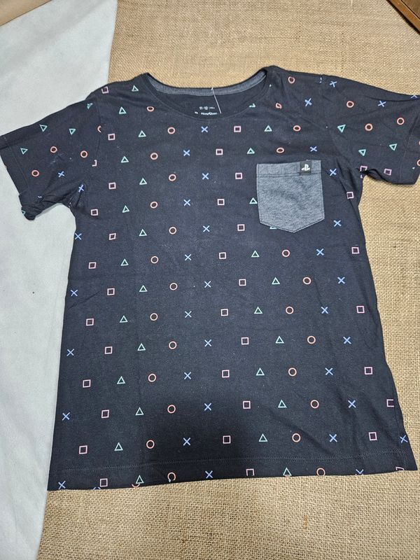 REMERA DE ALGODÓN, MANGA CORTA, PARA NIÑO, MARCA FUZARKA, TALLE 11-12. NEGRA CON DISEÑO PLAY, CON BOLSILLO GRIS