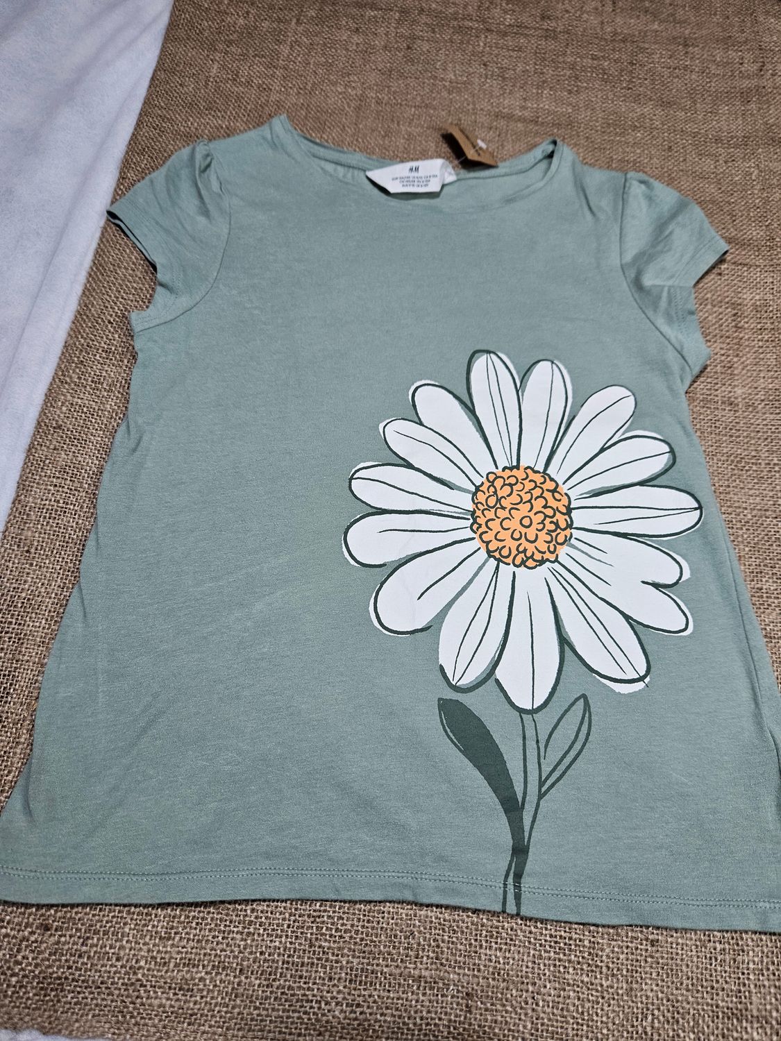 REMERA DE ALGODÓN, PARA NIÑA, CON ESTAMPA DE FLOR. COLOR VERDE MUSGO, MARCA HYM. TALLE 8/10. IMPECABLE