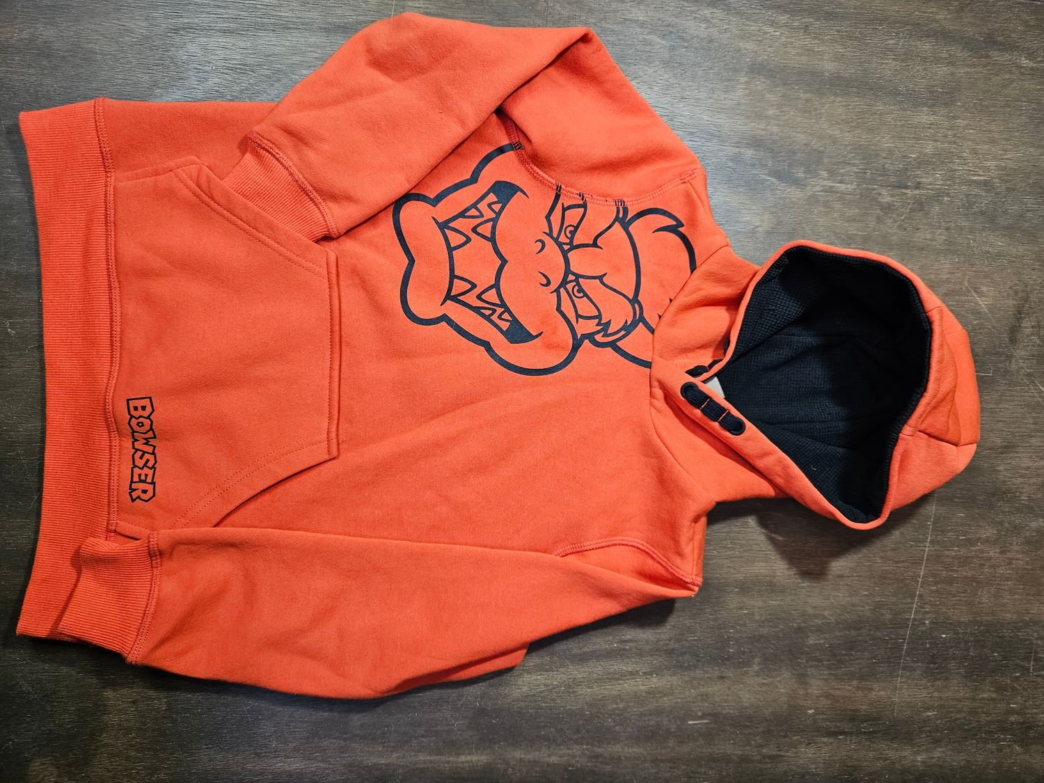 BUZO DEPORTIVO ESTILO CANGURO,CON CAPUCHA Y BOLSILLO, DE ALGOD�N, DISE�O SUPER MARIO, COLOR NARANJA, TALLE 7-8, MARCA RENNER. IMPECABLE IGUAL A NUEVO