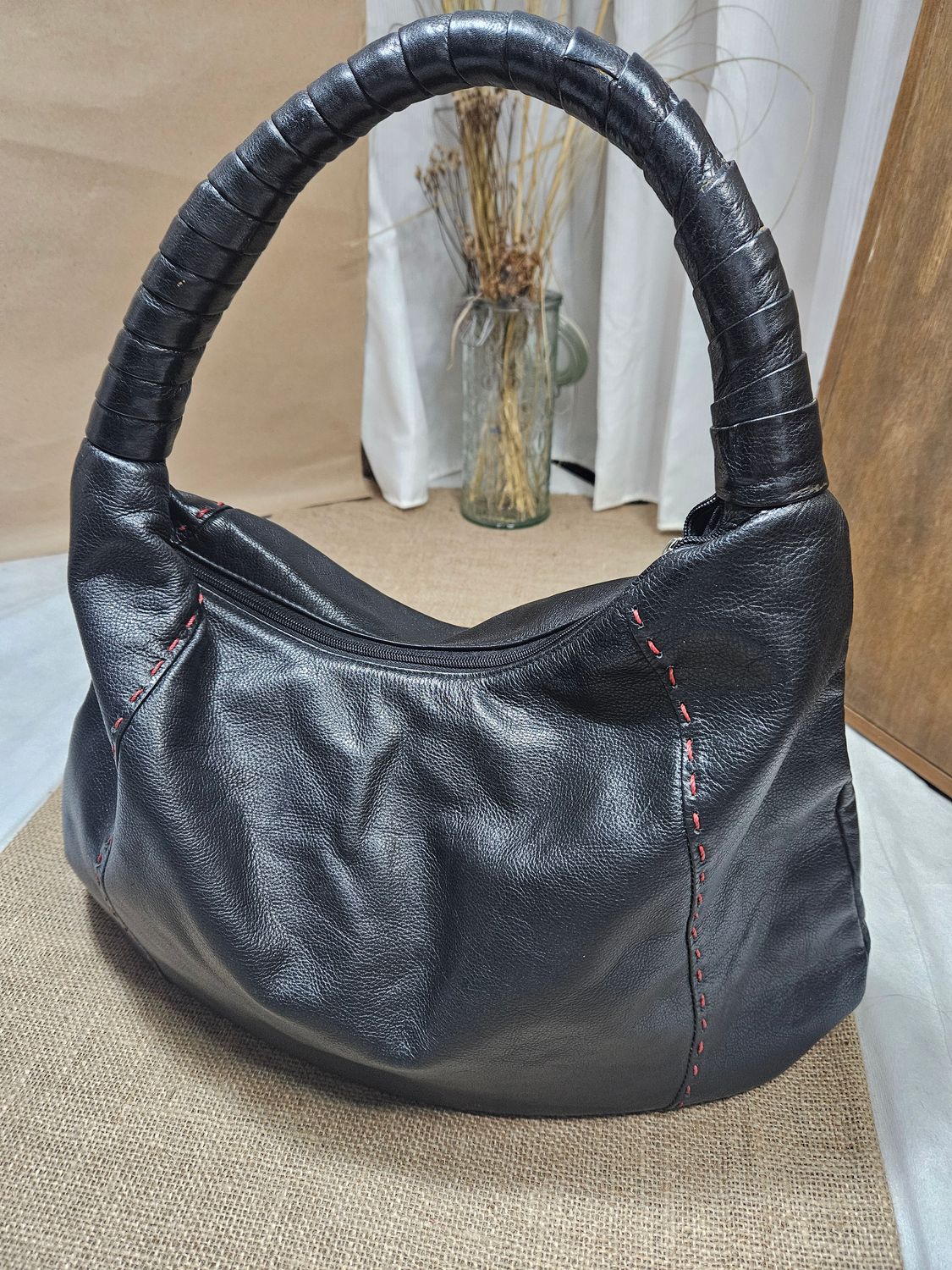 CARTERA ESTILO BOLSO, DE CUERO, CON UN ASA. PESPUNTES ROJOS