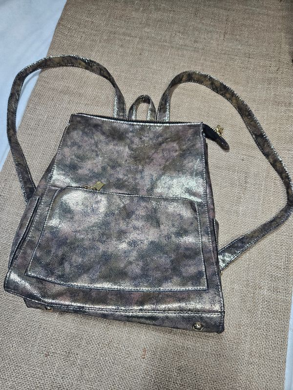 MOCHILA, EN SIMIL CUERO CON BRILLO DORADO. VARIOS CIERRES. IMPECABLE IGUAL A NUEVO