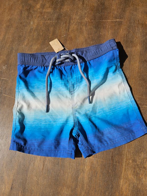 SHORT DE BAÑO PARA NIÑO, MARCA POIM, TALLE 4. AZUL DEGRADÉ. TIENE MUY PEQUEÑA MANCHA EN EL FRENTE
