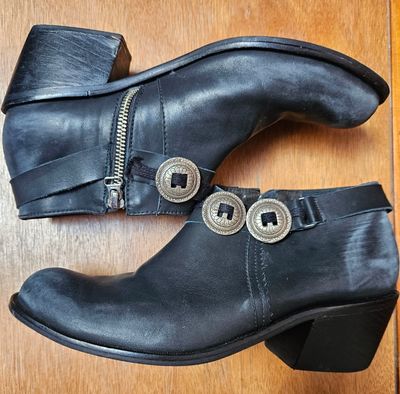 BOTAS CORTAS DE CUERO NEGRAS, CON SIMIL GASTADO EN PUNTA Y TALPÓN, CON PRECILLA CON APLIQUES METÁLICOS. TALLE 39. MARCA MARIA ANTONIETA