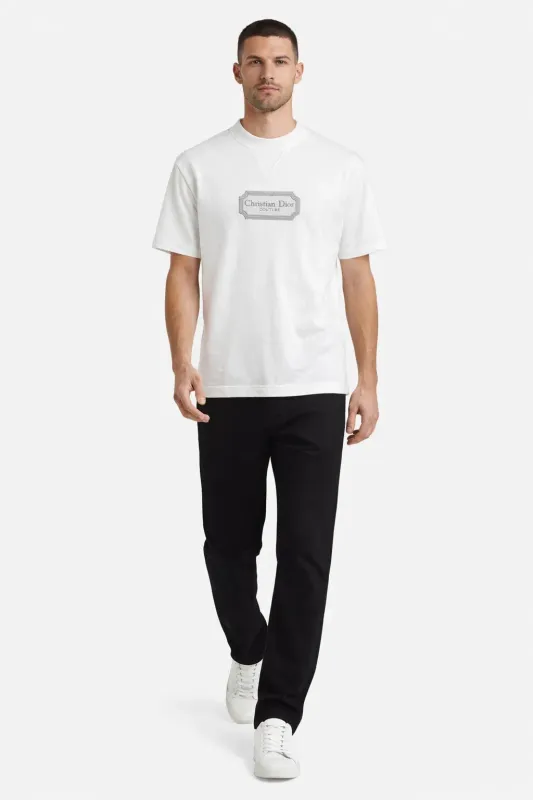 Male model walking wearing Christian Dior Couture white designer t-shirt luxury men's fashion outfit front walking pose