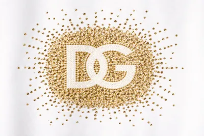 Dolce Gabbana gold stud DG logo close up detail on luxury white designer t shirt