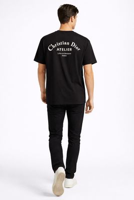 male model walking wearing black Christian Dior Atelier back logo designer t shirt luxury men's Dior Paris fashion