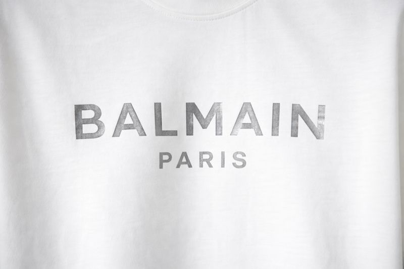 Close-up of Balmain Paris silver logo print on men’s white designer T-shirt