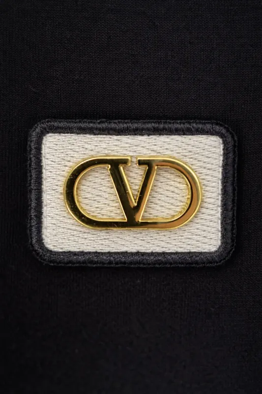 Valentino Garavani minimal logo black t shirt gold chest logo close up detail