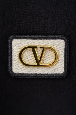 Valentino Garavani minimal logo black t shirt gold chest logo close up detail