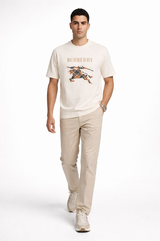 Male model walking while wearing Burberry cream luxury t-shirt with embroidered logo in studio fashion photoshoot