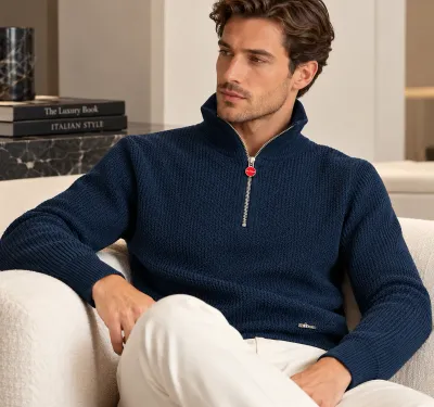 Kiton navy blue half zip knit sweater for men worn by a seated model with cream trousers, featuring textured knit fabric, red