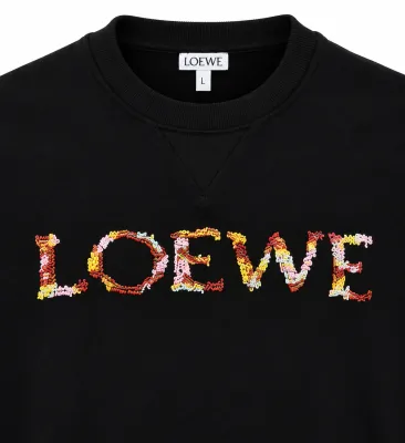 Loewe black sweatshirt close-up showing multicolor embroidered logo and ribbed collar