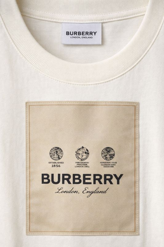 Burberry cream men's designer t-shirt close up featuring signature logo patch and premium cotton texture