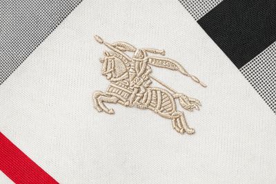 Burberry men's designer t-shirt logo close up featuring embroidered equestrian knight on multicolor check pattern fabric