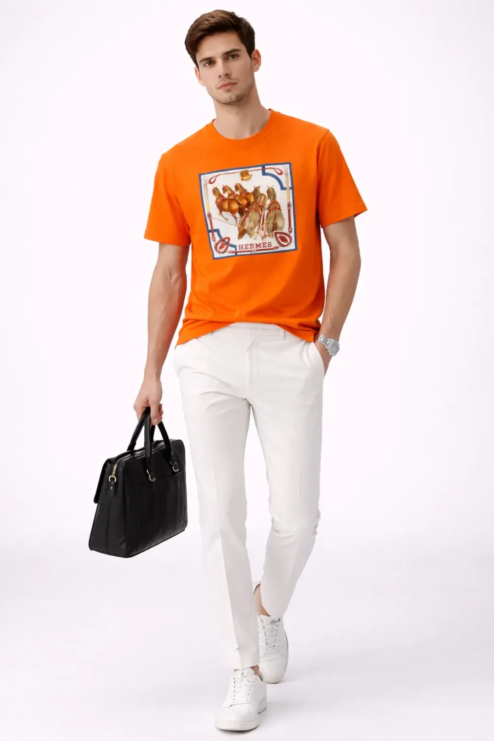 Male model wearing Hermes orange luxury designer tee with white pants in studio