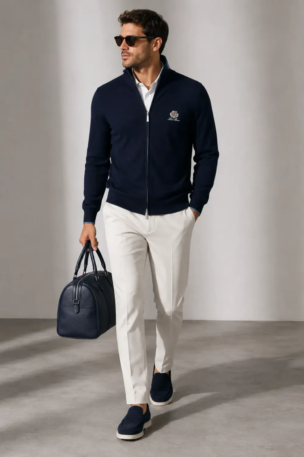 loro piana navy blue full zip sweater men walking model with embroidered crest logo