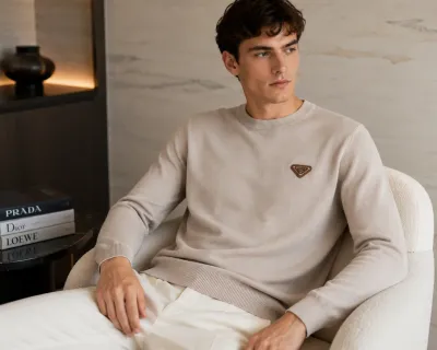 prada light beige knit sweater men seated model wearing signature triangle logo design