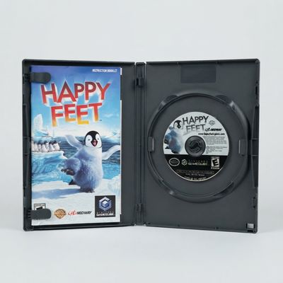 Open Nintendo GameCube case showing the Happy Feet game disc and instruction booklet