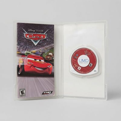 Open case for Pixar Cars on PSP containing the instruction manual and red UMD game disc