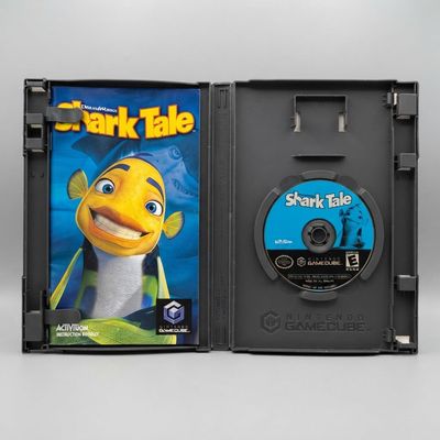 Open black case for DreamWorks Shark Tale on Nintendo GameCube showing the instruction manual and blue game disc
