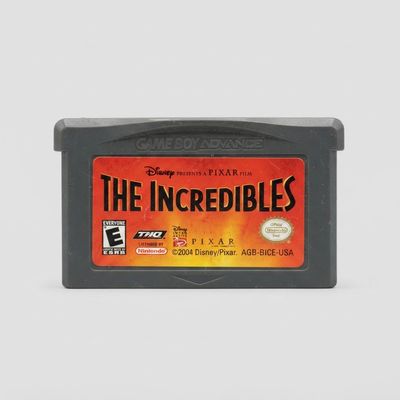 Front view of a grey The Incredibles Game Boy Advance cartridge with a red and orange label and minor surface scratches