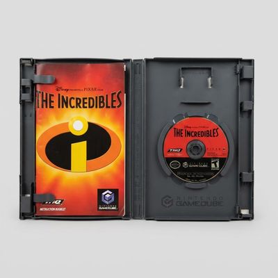 Open Nintendo GameCube case for The Incredibles showing the orange manual and red game disc