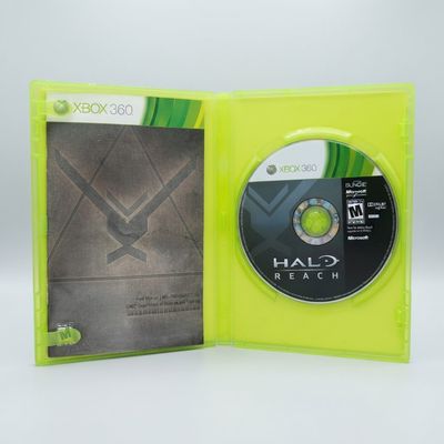 Open lime green Xbox 360 case showing the Halo: Reach game disc and manual contents