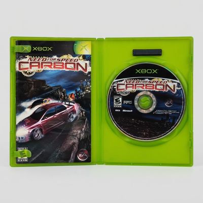 Open green case showing the Need for Speed Carbon Xbox disc and instruction manual inside