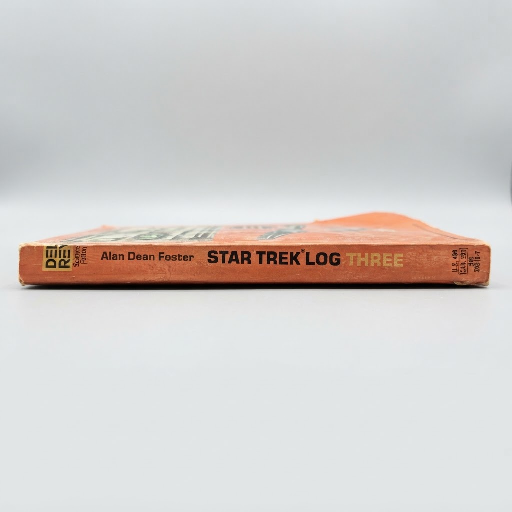 The spine of a vintage orange Star Trek Log Three paperback book by Alan Dean Foster with Del Rey branding