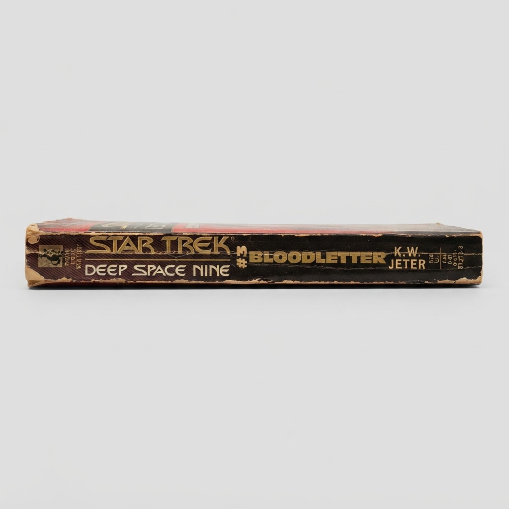 Spine view of the vintage Star Trek: Deep Space Nine Bloodletter paperback featuring worn edges and gold lettering