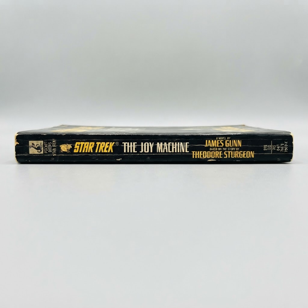 Black spine of the vintage paperback Star Trek: The Original Series The Joy Machine with worn edges and yellow text