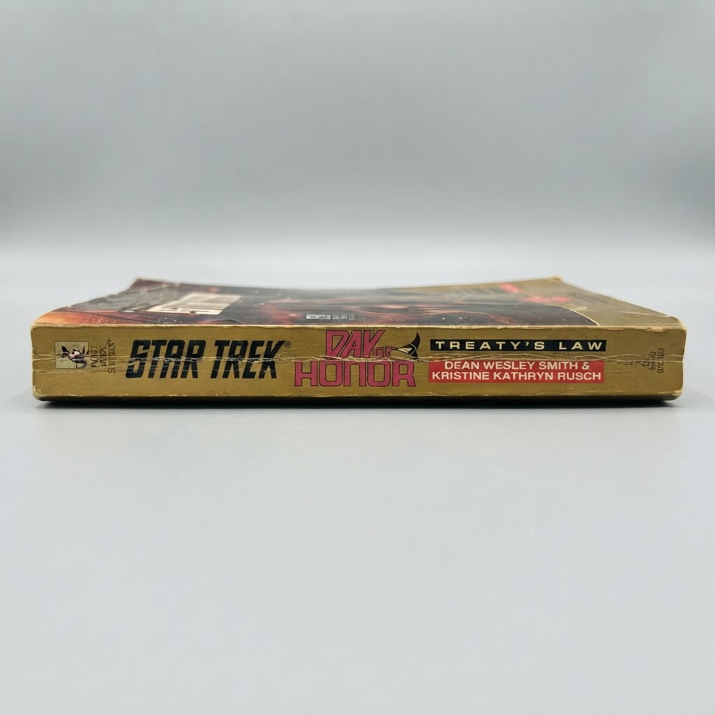 Spine view of the vintage Star Trek Day of Honor Treaty's Law paperback featuring gold text and light edge wear