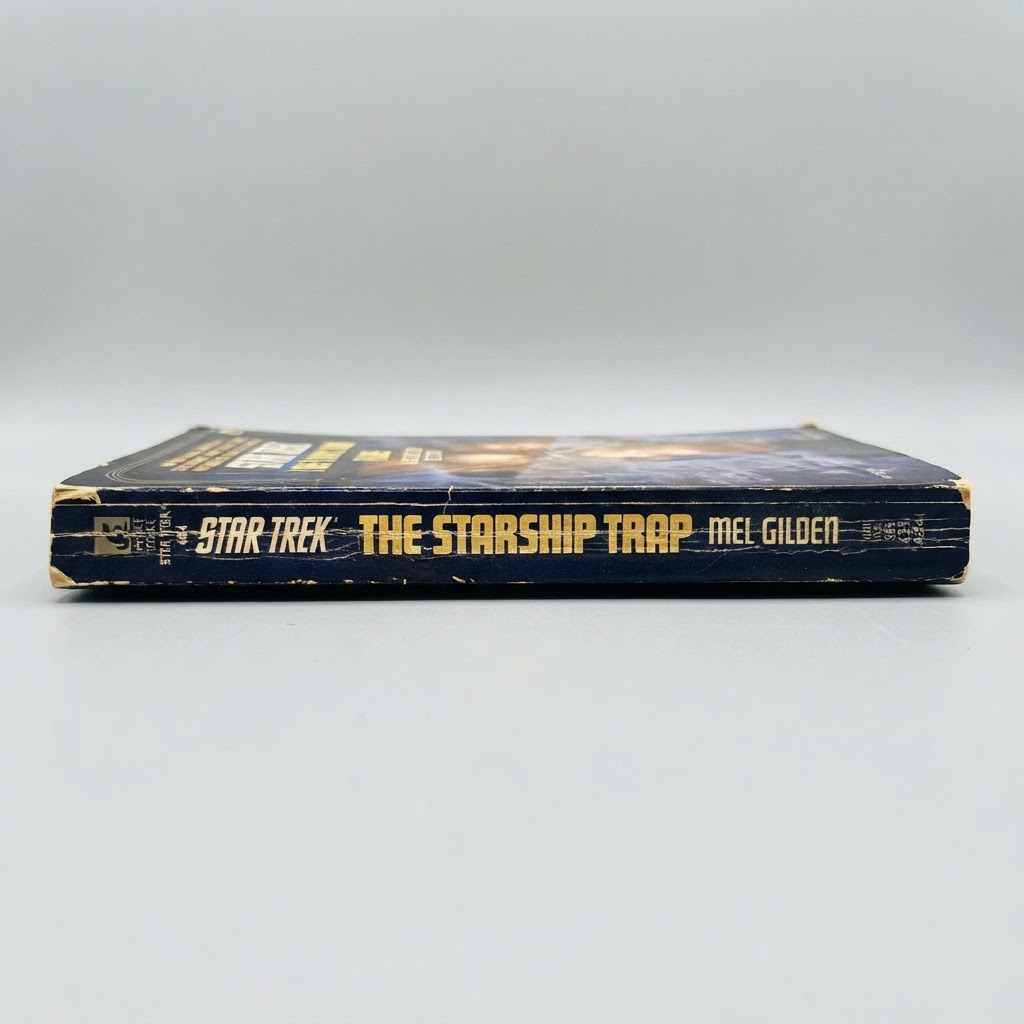 The spine of the vintage Star Trek: The Original Series The Starship Trap paperback shows some edge wear