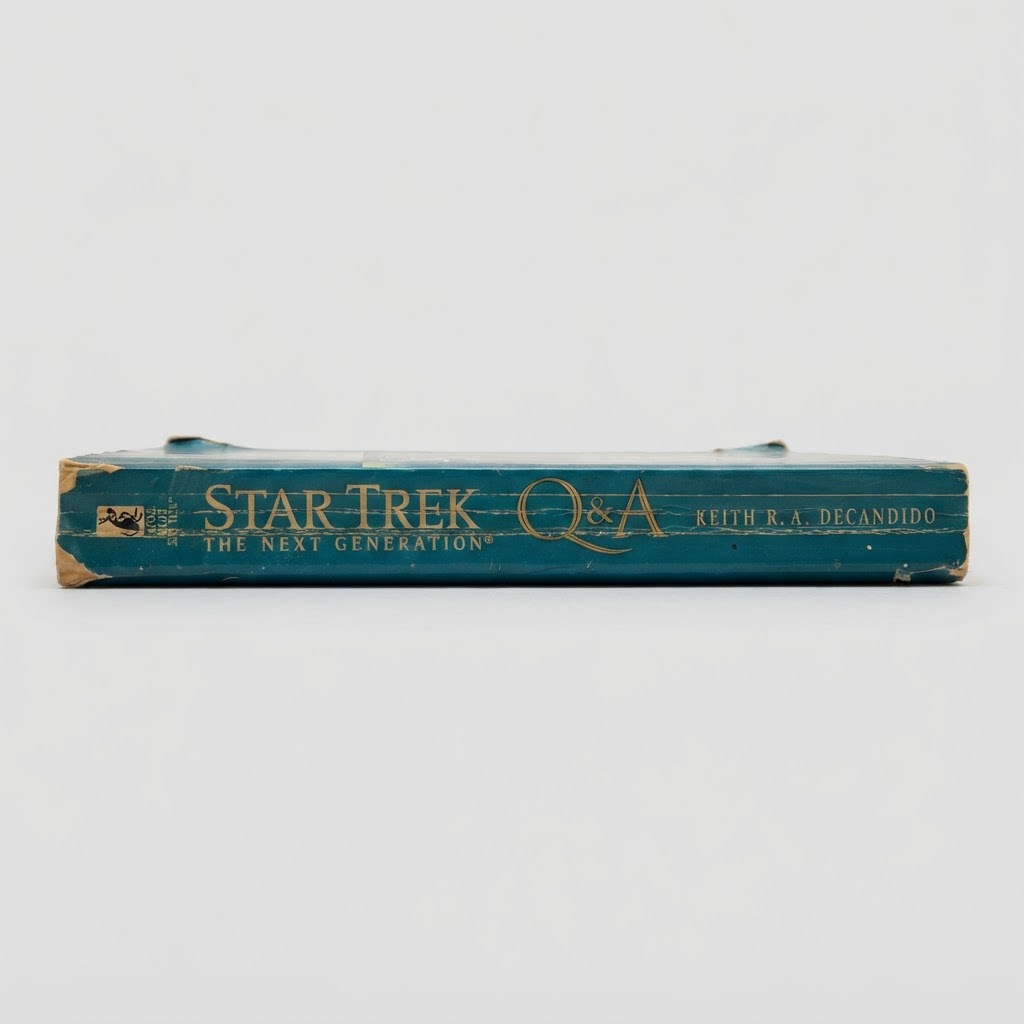 Teal spine of the vintage Star Trek: TNG "Q & A" paperback showing wear and gold lettering