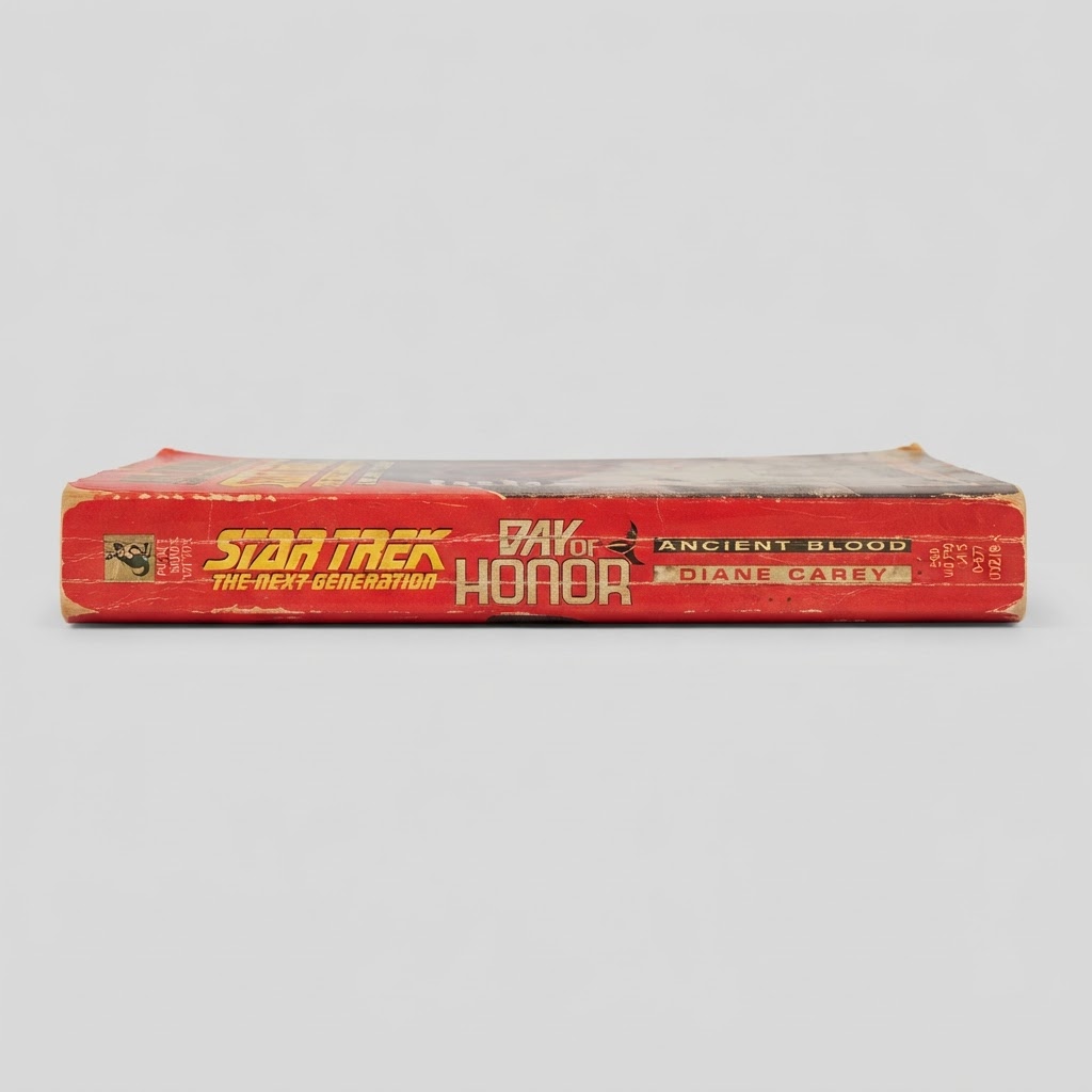 Spine of a worn vintage Star Trek Day of Honor Ancient Blood paperback featuring gold lettering on a red background