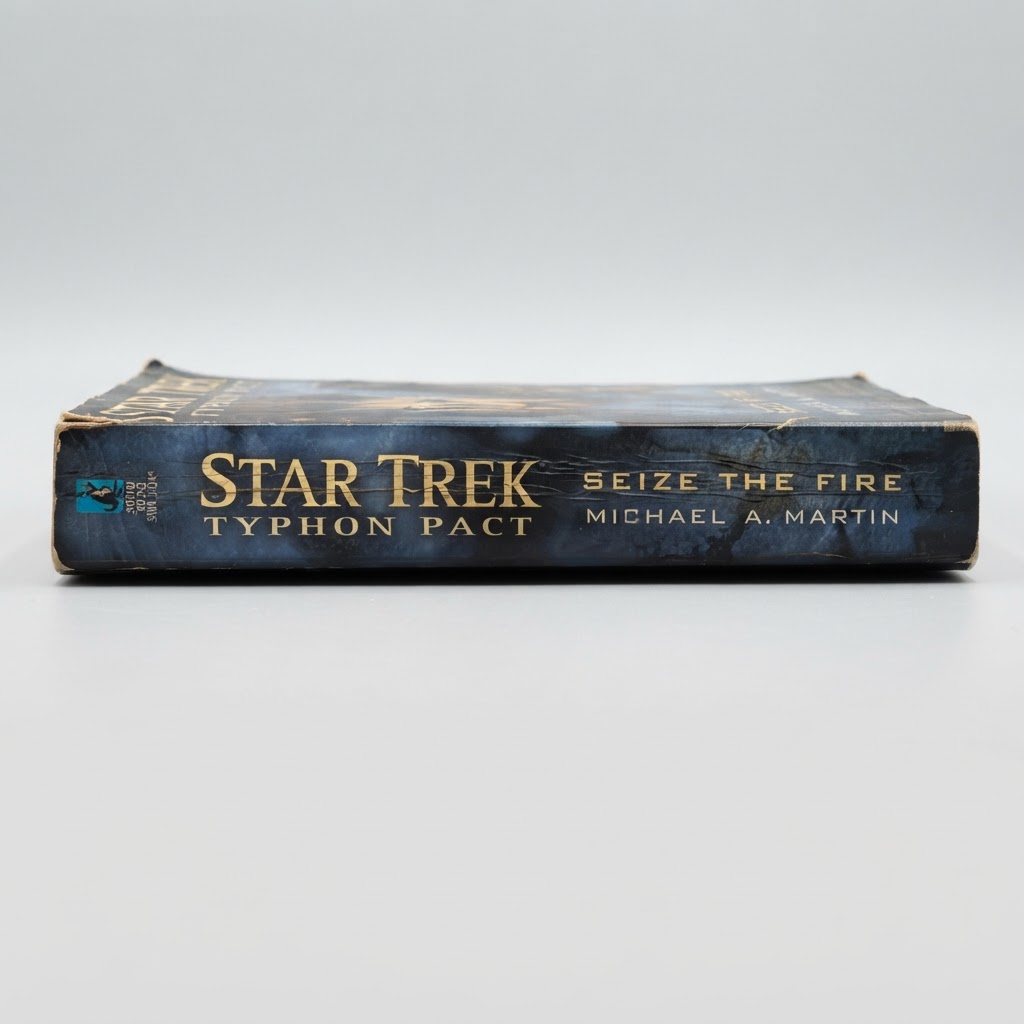 The spine of a worn Star Trek Typhon Pact Seize the Fire paperback book against a light background
