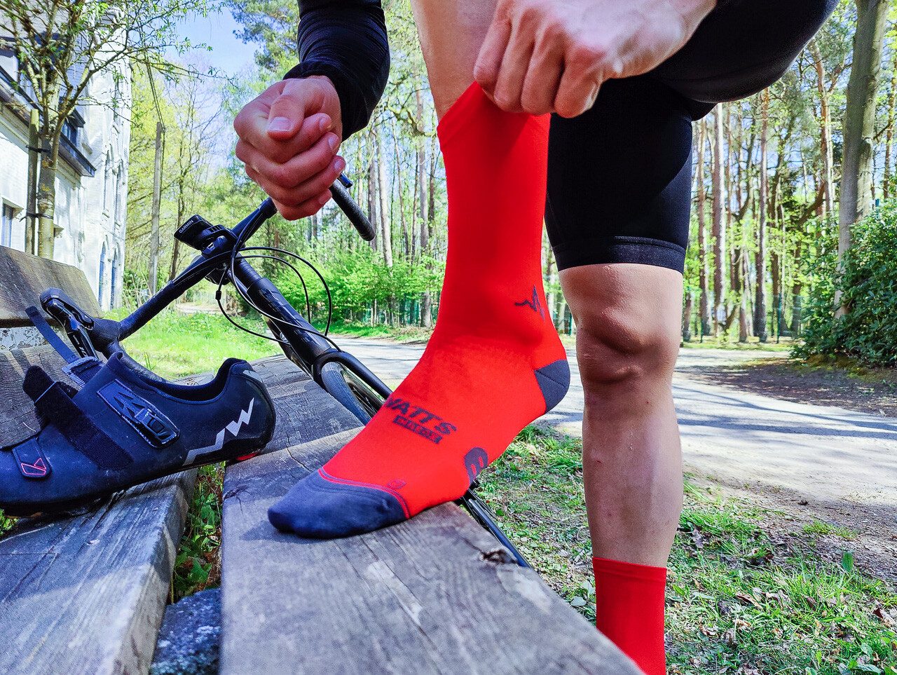 Cyclist wearing Beat Pusher colorful cycling socks pushing hard on road