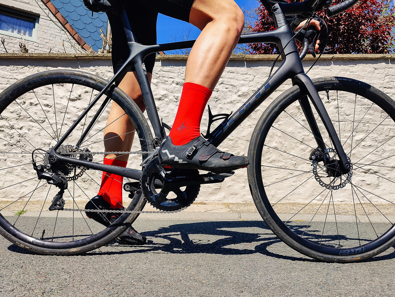 Cyclist wearing Beat Pusher colorful cycling socks pushing hard on road
