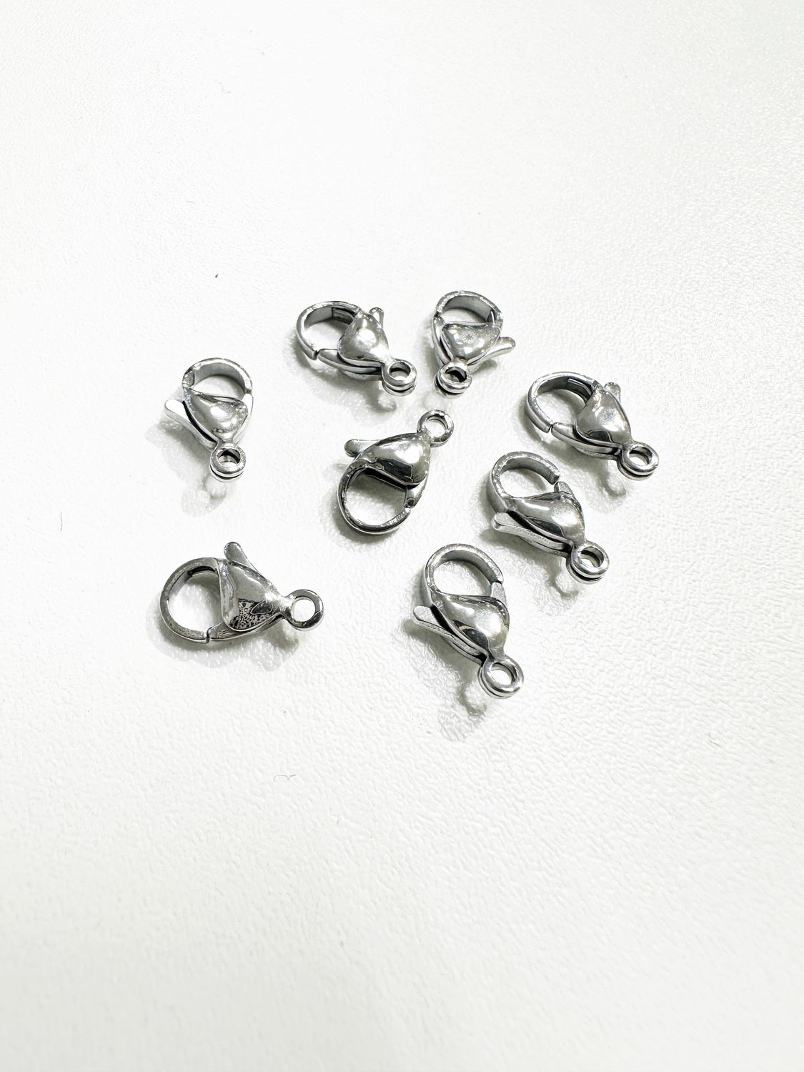 Nerūdijančio plieno užsegimai, plieno spalvos 12x7mm, 4vnt