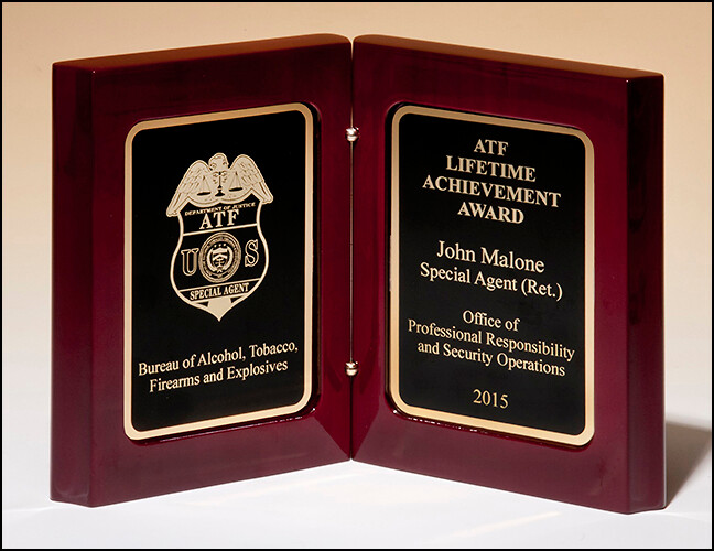 High gloss rosewood stained book award. Two gold plates with black centers