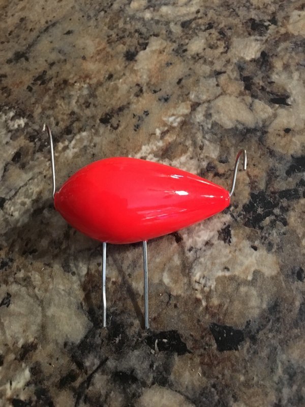 orange balsa wood bobber settled in a rock