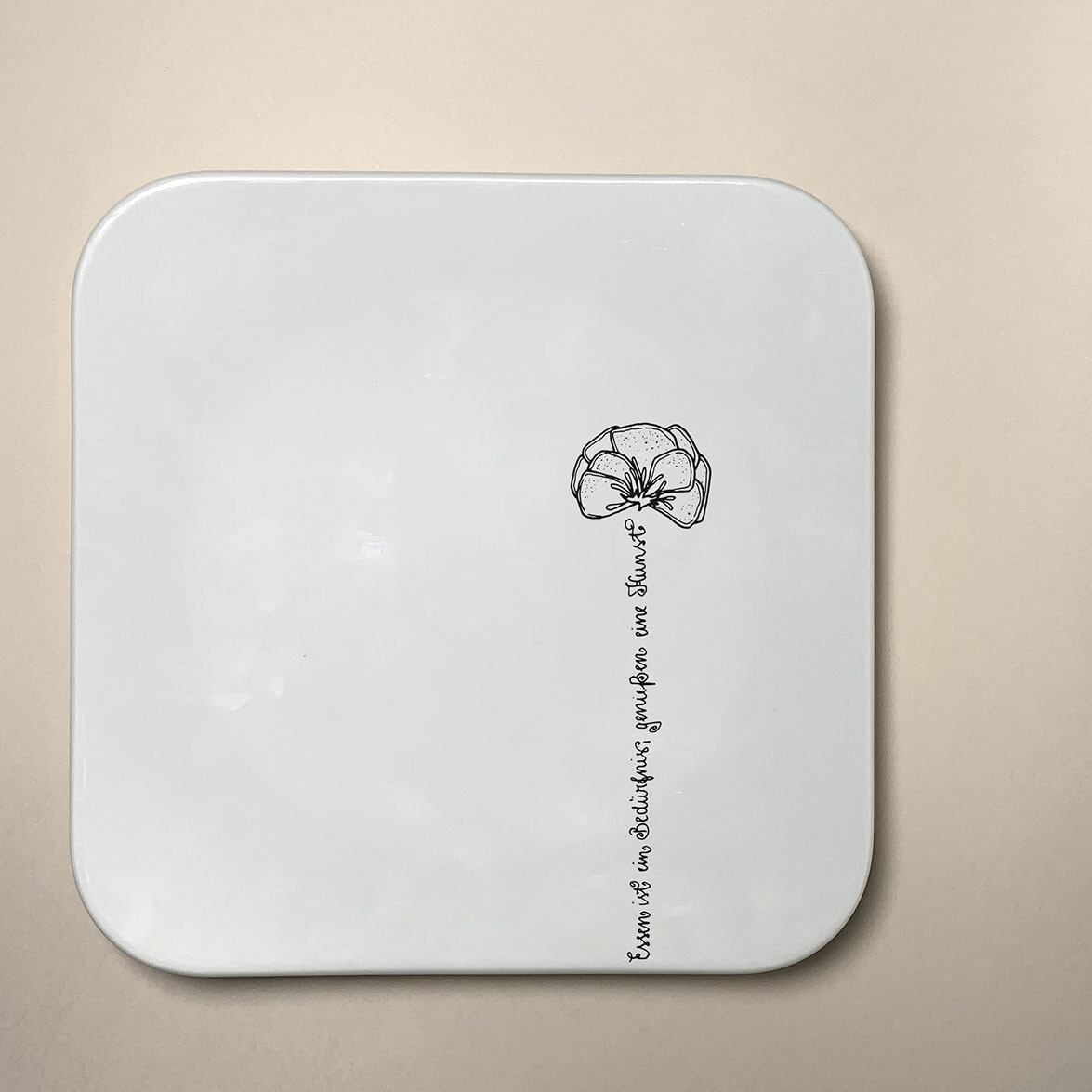 "Blumengruß" (Teller, abgerundet, 26 x 26 cm), Stückzahl: 1 Teller, Spruch: Essen ist ein Bedürfnis, genießen eine Kunst