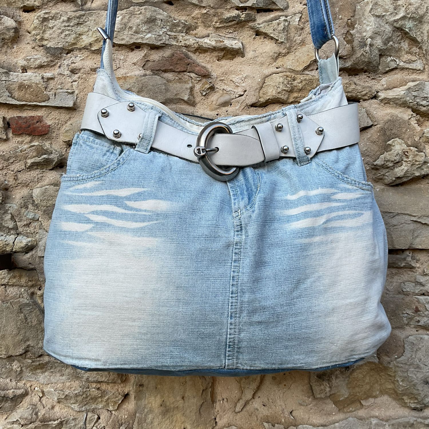 Hellblaue Jeanstasche mit Ledergürtel