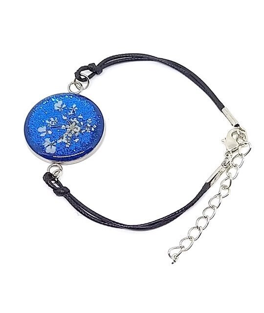 Bracelet cordon/inox, fleur de Carotte, fond bleu pailleté. D25mm