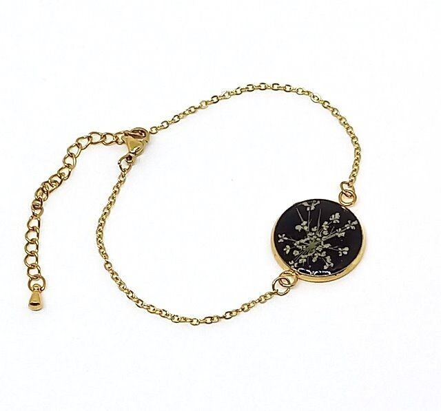 Bracelet doré fleur de Carotte, fond noir. D25mm