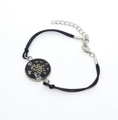 Bracelet cordon/inox, fleur de Carotte, fond noir. D20mm