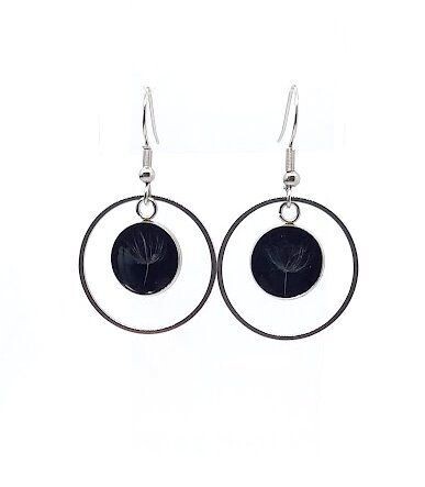 ​Boucles d'oreilles pendantes, graines de Pissenlit sur fond noir.