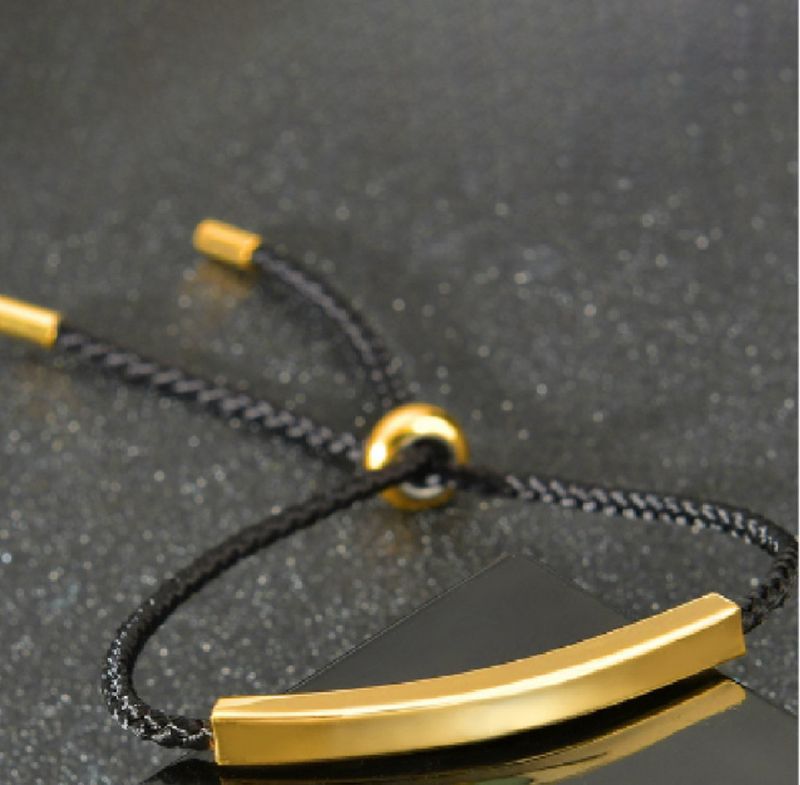 Pulsera cordón negro con placa dorada de acero inoxidable